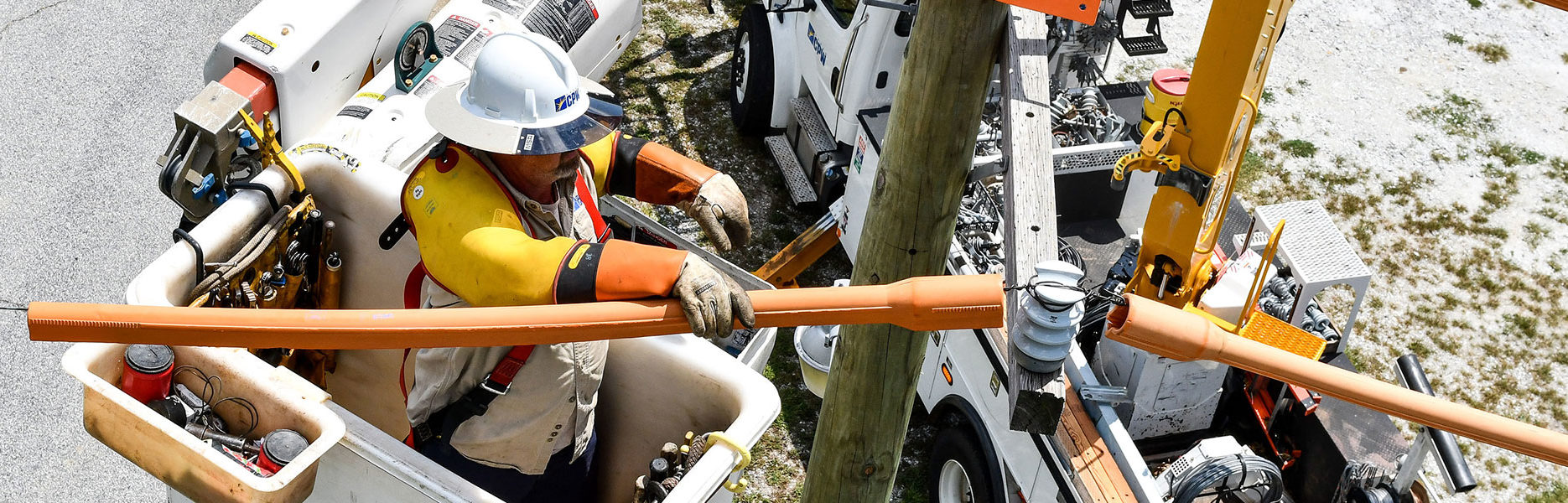 CPW employee working in a bucket truck on electrical lines