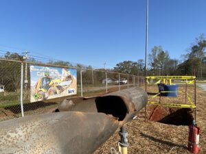 photo of a damaged pipe in front of a sign that says call 811 before you dig