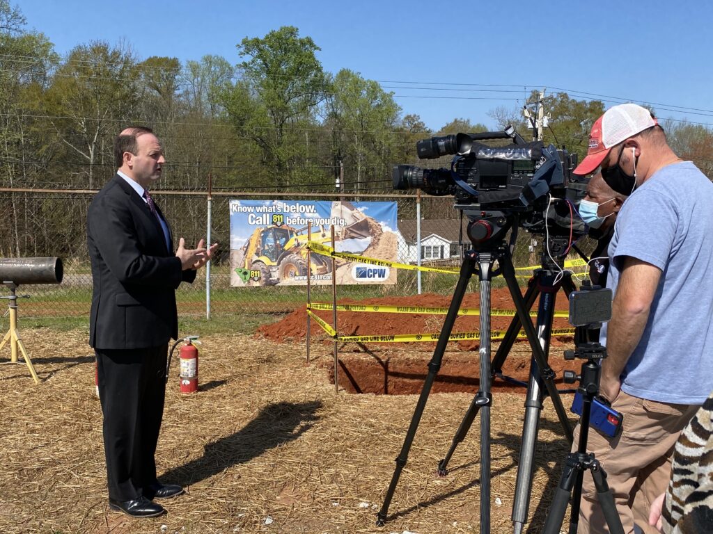 speaker in front of news cameras at the safe digging event