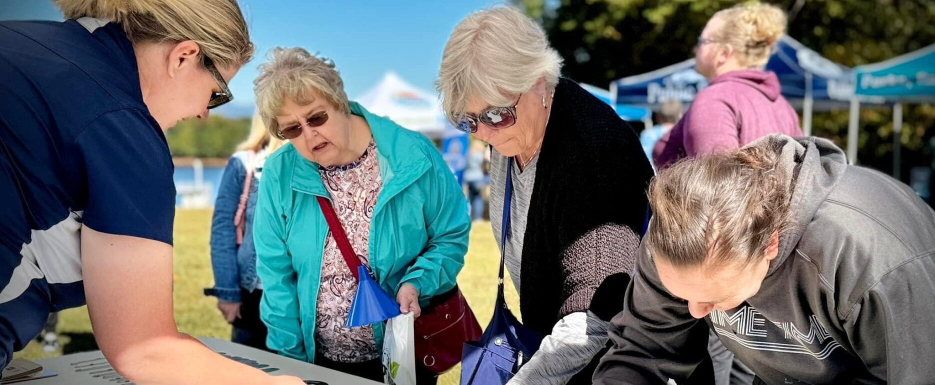 group of people looking at a booth at Lake Robinson day